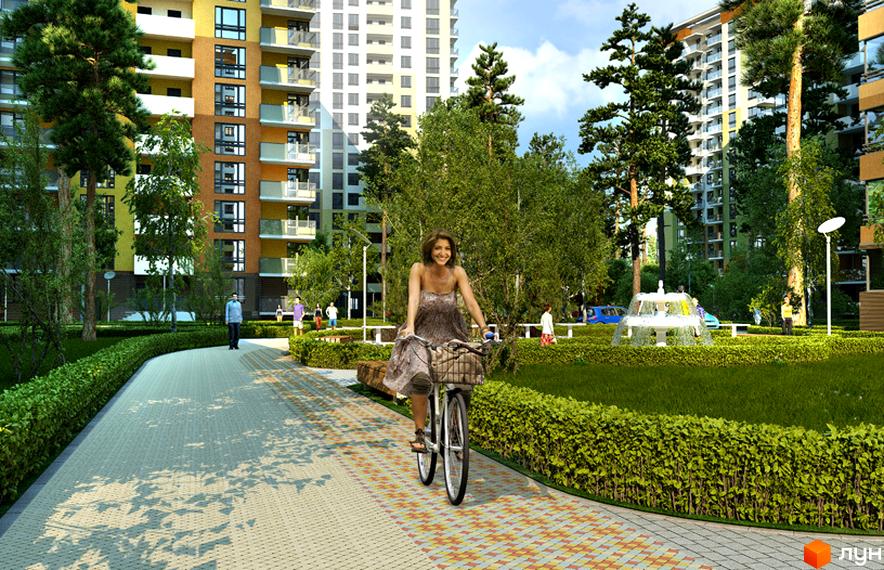 Зовнішній вигляд житлового комплексу ЖК Відпочинок з сучасними будинками та зеленими прибудинковими територіями. На алеї велосипедистка та перехожі серед зелені.