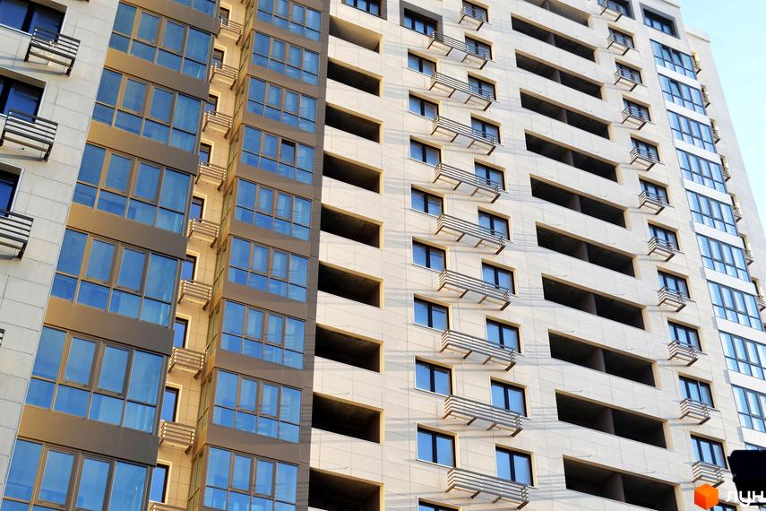 Житловий комплекс Островського, 40 з фасадом з великими вікнами та балконами. Прибудинкова територія з зеленими насадженнями.