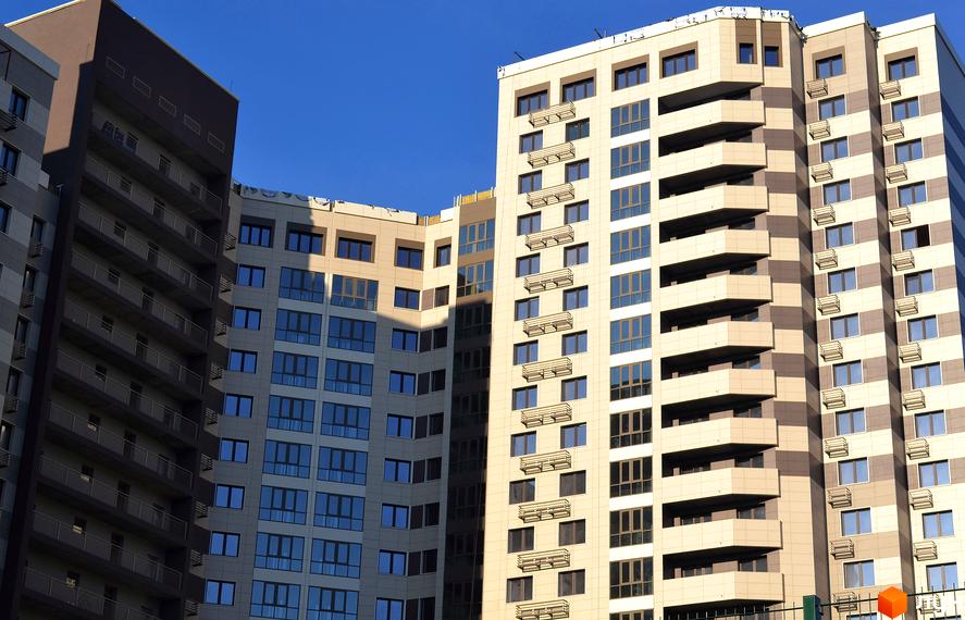 Житловий комплекс Островського, 40. Багатоповерхові будинки з балконами та великими вікнами на фоні блакитного неба.