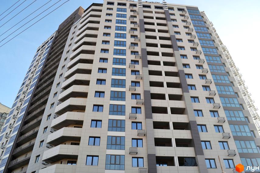 Зовнішній вигляд новобудови ЖК Островського, 40, з численними балконами та великими вікнами. Будинок має багатоповерхову структуру та сучасний дизайн фасаду.