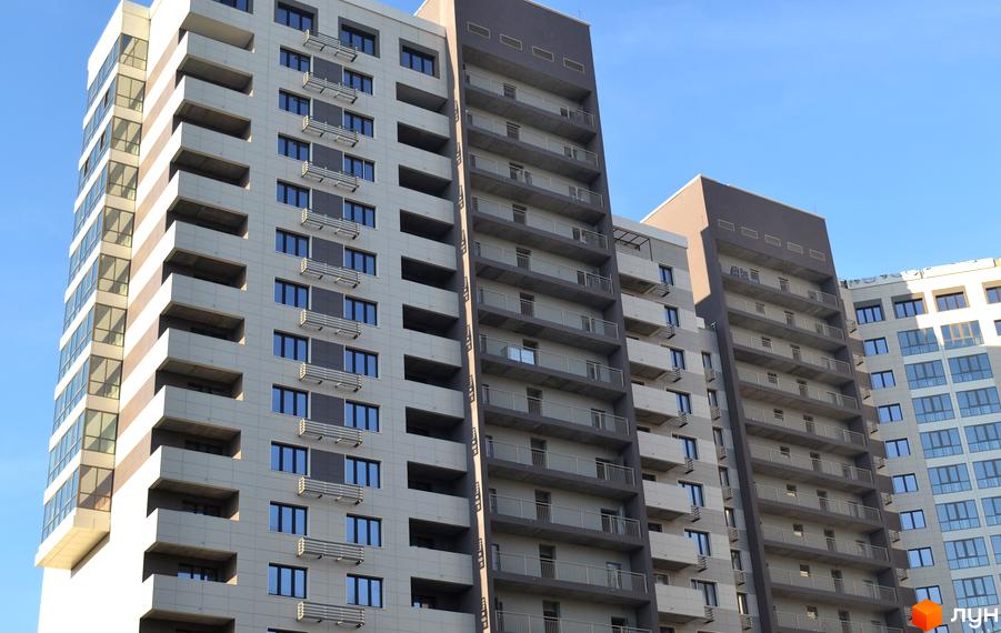 Житловий комплекс Островського, 40 – багатоповерхові будинки з балконами та великими вікнами на фоні блакитного неба. Зовнішній вигляд новобудов.