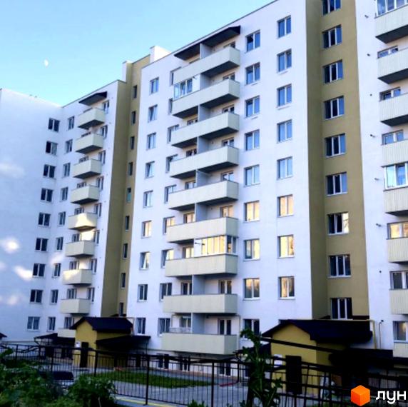 Зовнішній вигляд багатоквартирного будинку на вул. Тарнавського, 7, з балконами та прибудинковою територією.