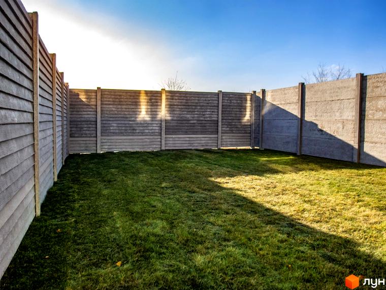 Огорожа Таунхаус „Європейський“ з бетонних панелей під дерево та гладких, і доглянутий зелений газон.