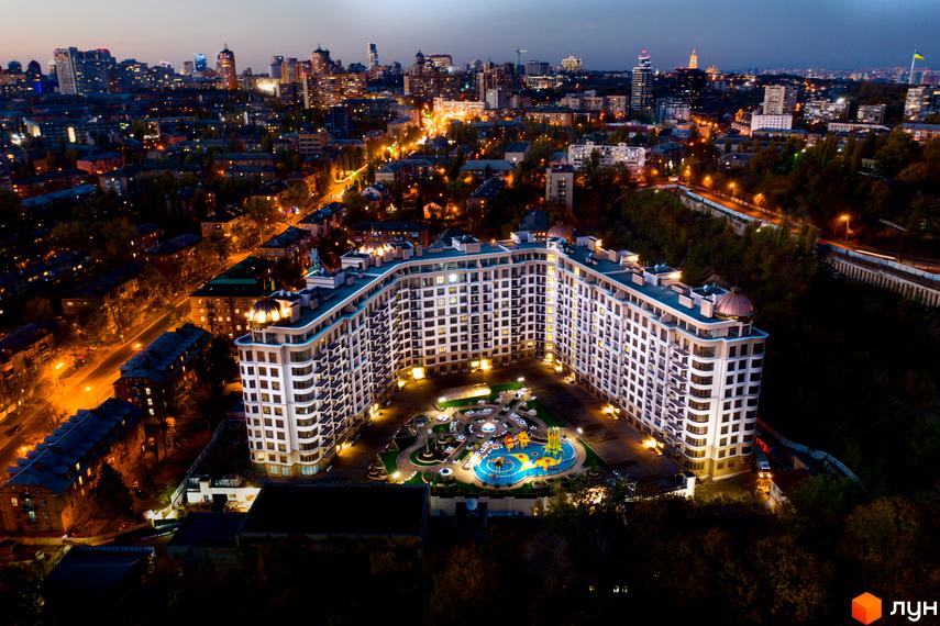 Житловий комплекс 52 Перлина (Pechersk Plaza) вночі з висоти пташиного польоту. Висотна будівля з великою прибудинковою територією та дитячим майданчиком.