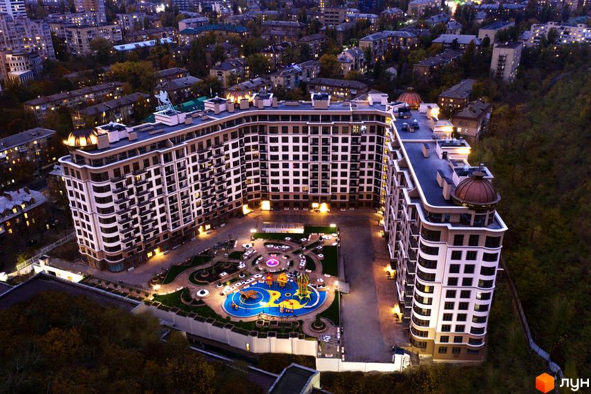 Житловий комплекс 52 Перлина (Pechersk Plaza) з великою прибудинковою територією та дитячим майданчиком. Багатоповерховий будинок з панорамними вікнами та архітектурними елементами.