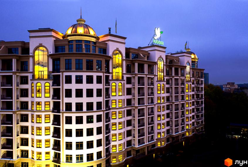 Висотна будівля ЖК 52 Перлина (Pechersk Plaza) з великою кількістю вікон та золотим куполом. На даху розташована вивіска з логотипом.