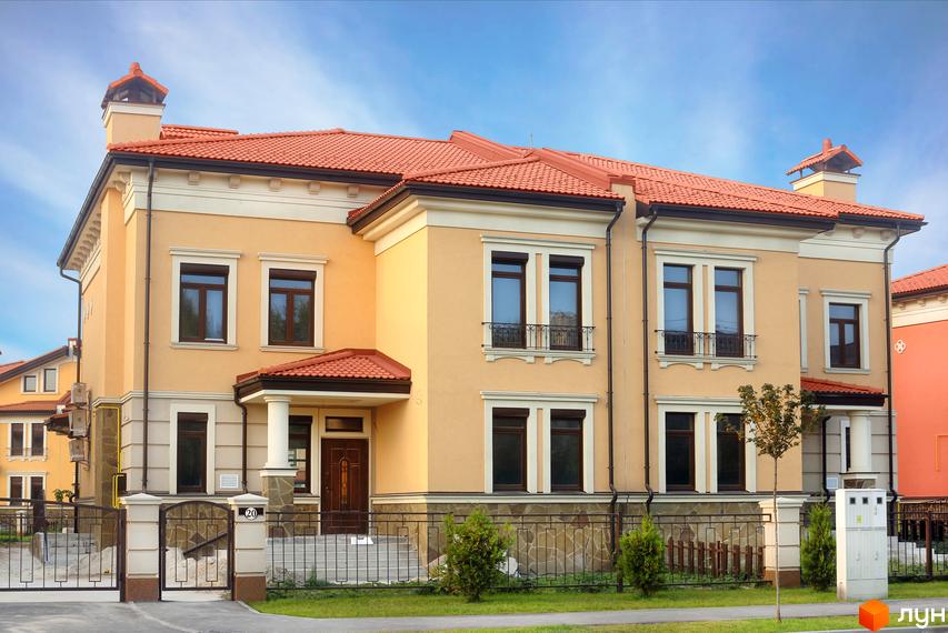 Котеджне містечко Італійський квартал. Фасад будинку виконаний у світло-жовтих тонах з червоним дахом, вікна з темними рамами. Огороджена територія з елементами ландшафтного дизайну.