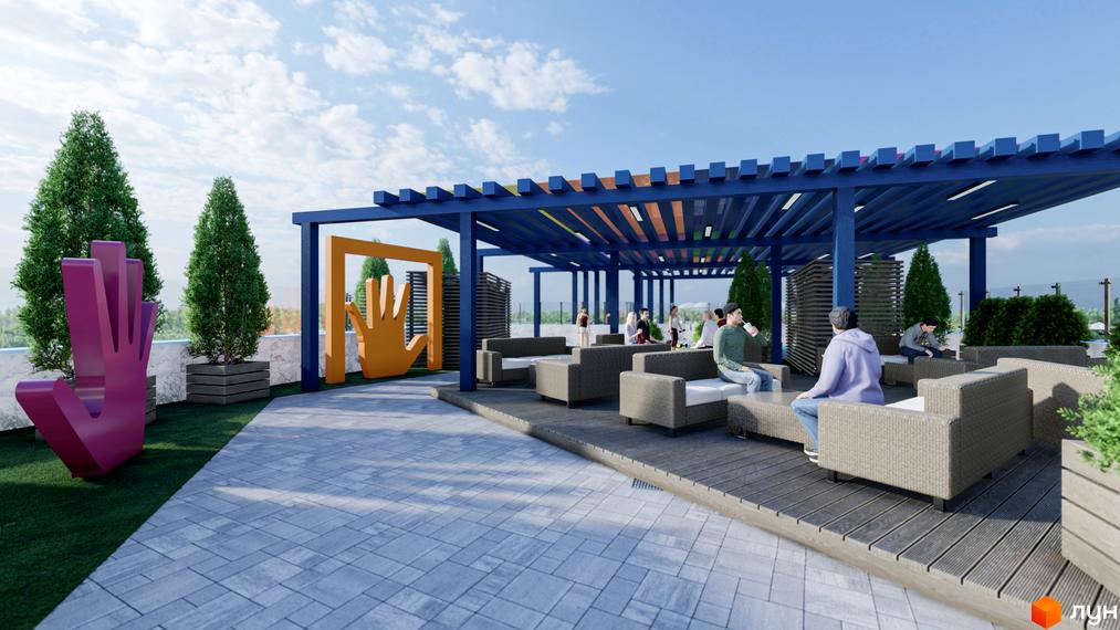 Тераса житлового комплексу Калейдоскоп з місцями для відпочинку та декоративними елементами. На території розміщені диванні групи під навісом та зелені насадження.