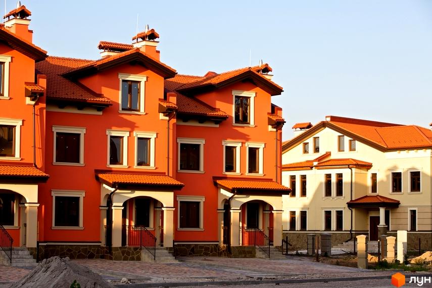 Котеджне містечко Італійський квартал. Будинки з помаранчевими та кремовими фасадами, дахи вкриті червоною черепицею.