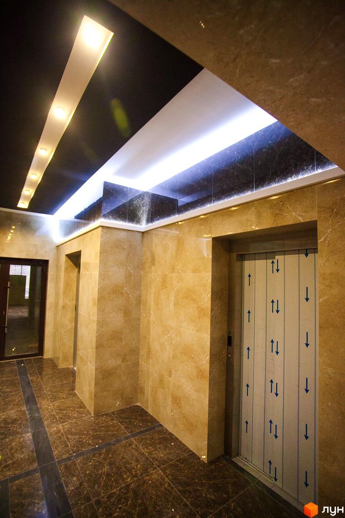 Інтер'єр холу Житлового комплексу Paradise з ліфтом та освітленням. Оздоблення стін та підлоги виконано з мармуру.