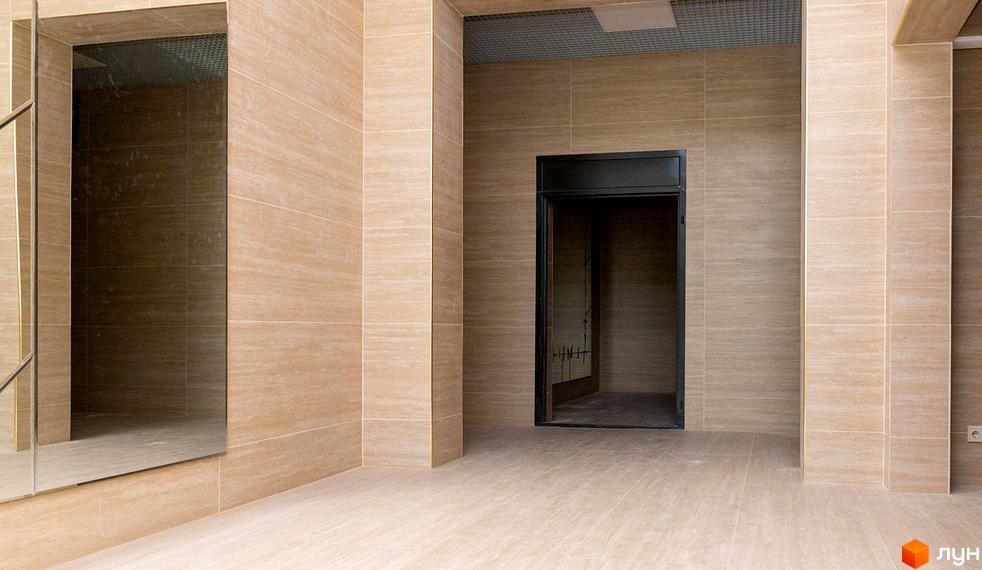 Житловий комплекс Ярославів Град, внутрішній простір з оздобленням стін та підлоги під мармур, двері ліфта та дзеркало.