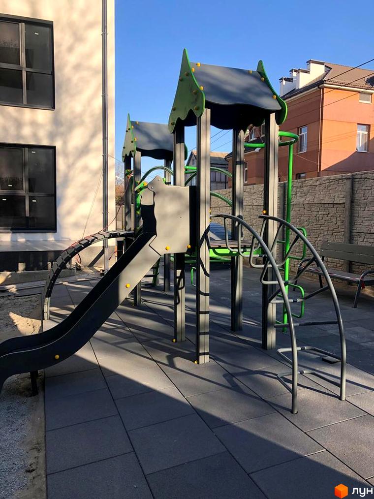 Зображення дитячого майданчика біля Клубних будинків „На Генерала Пушкіна“. Гірка та спортивні конструкції на території.