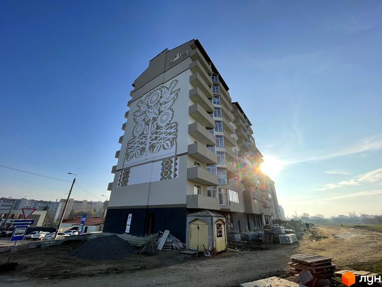 Гармонія Арт на вул. Горбачевського. Багатоповерховий будинок з художнім муралом на фасаді та балконами, навколо триває будівництво.