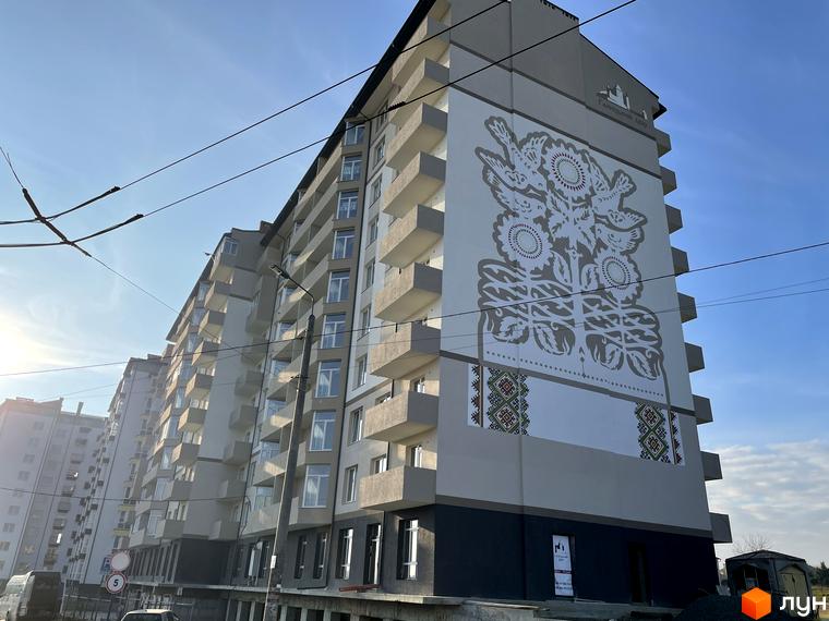 Новобудова Галицький двір на вул. Горбачевського. Фасад прикрашений великим муралом із зображенням птахів, соняшників та традиційних візерунків.