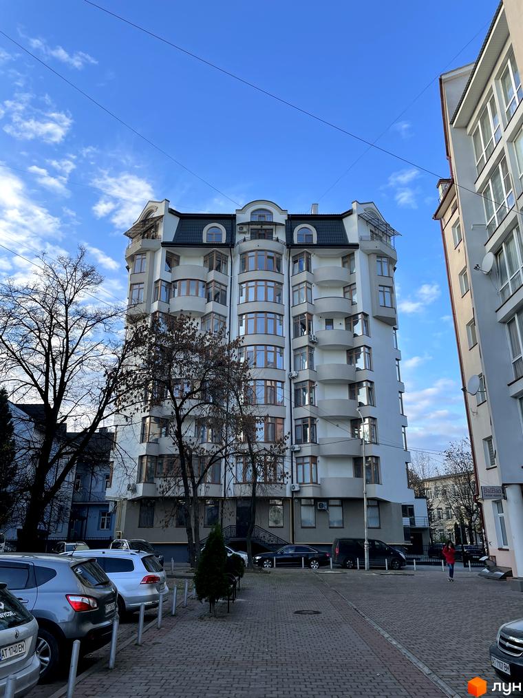 Зображення будинку на вул. Короля Данила, 20. Багатоповерхова будівля з балконами та великими вікнами, поруч припарковані автомобілі.