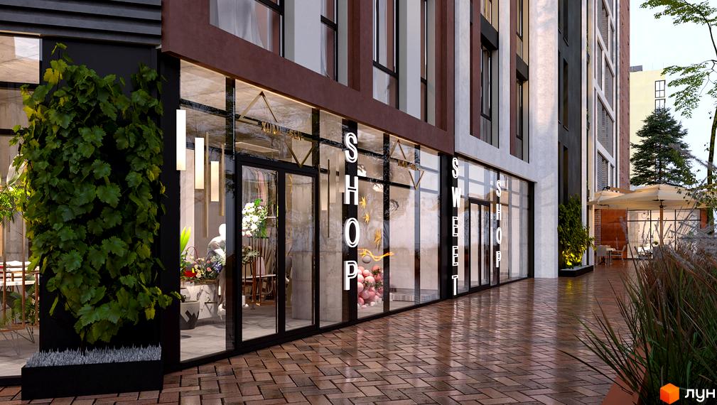 Фасад Житлового комплексу Mill Town з великими вітринами магазинів на першому поверсі. Прибудинкова територія викладена бруківкою, з зеленими насадженнями та літнім кафе.