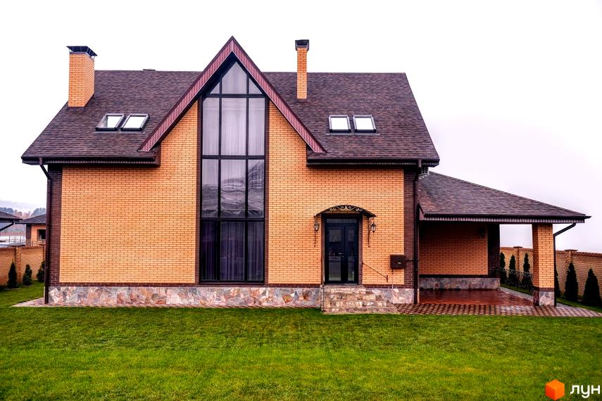 Зображення фасаду будинку в Котеджному містечку Розкішне. На передньому плані газон з травою.