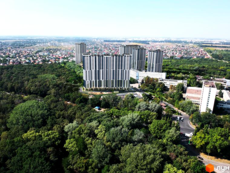 Житловий комплекс Авеню 42 - це сучасна новобудова з високими будинками та зеленою прибудинковою територією. На зображенні видно кілька багатоповерхових будинків, оточених деревами та міським пейзажем.