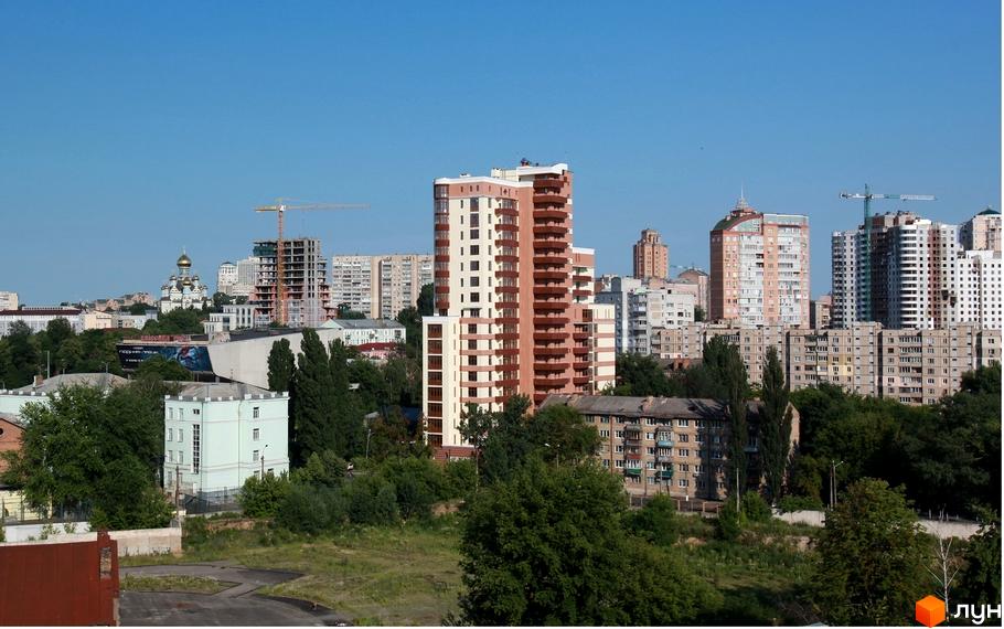 Житловий комплекс на вул. Коперника, 11, з сучасними фасадами та прибудинковою територією, оточений зеленими насадженнями.