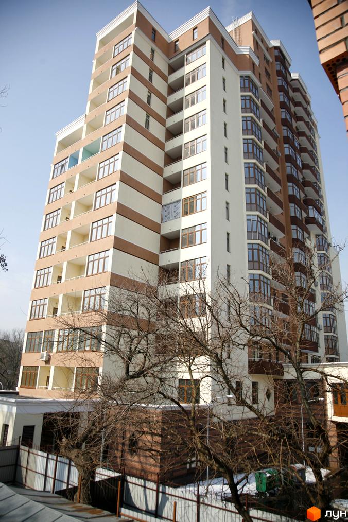 Житловий комплекс на вул. Коперника, 11, з сучасною архітектурою та прибудинковою територією з деревами.