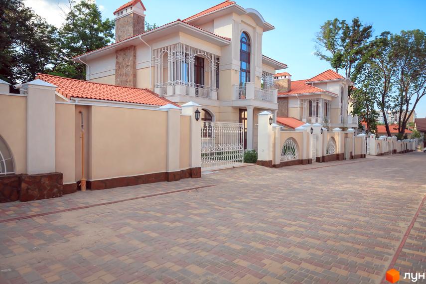 Оазис - Котеджне містечко з будинками з черепичними дахами та світлими фасадами. На території комплексу брукована дорога та ковані ворота.