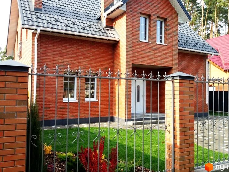 Котеджне містечко КМ Pine Wood • mini: цегляний будинок з металевим парканом та доглянутою прибудинковою територією з газоном та рослинами.