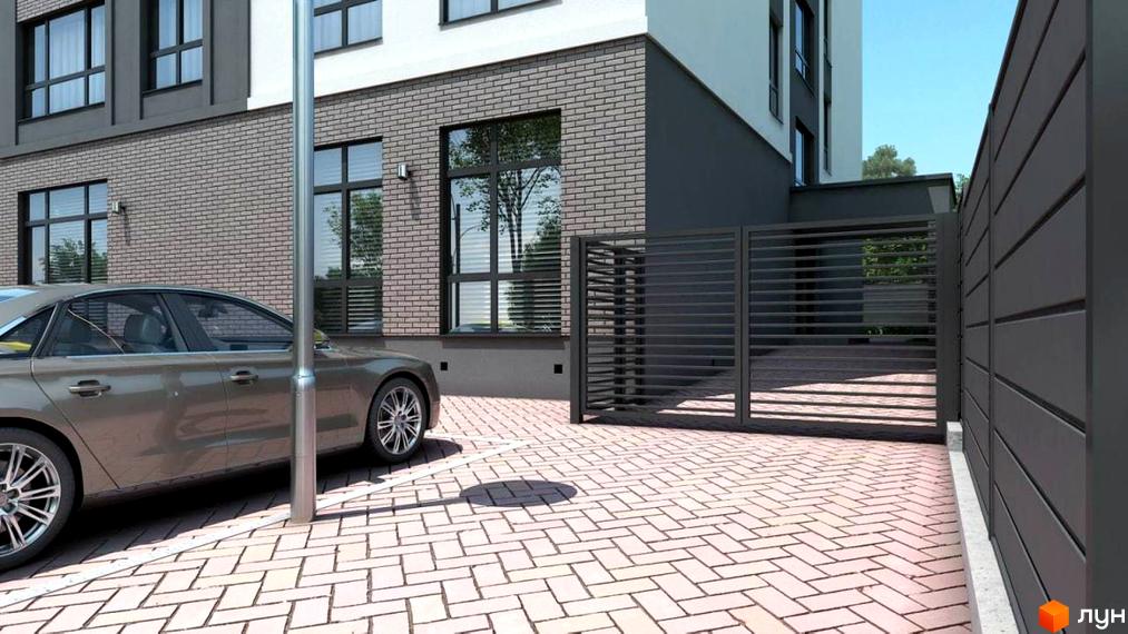 Клубний будинок Range з сірою цегляною фасадною частиною та парковкою з бруківки, огородженою темним парканом.