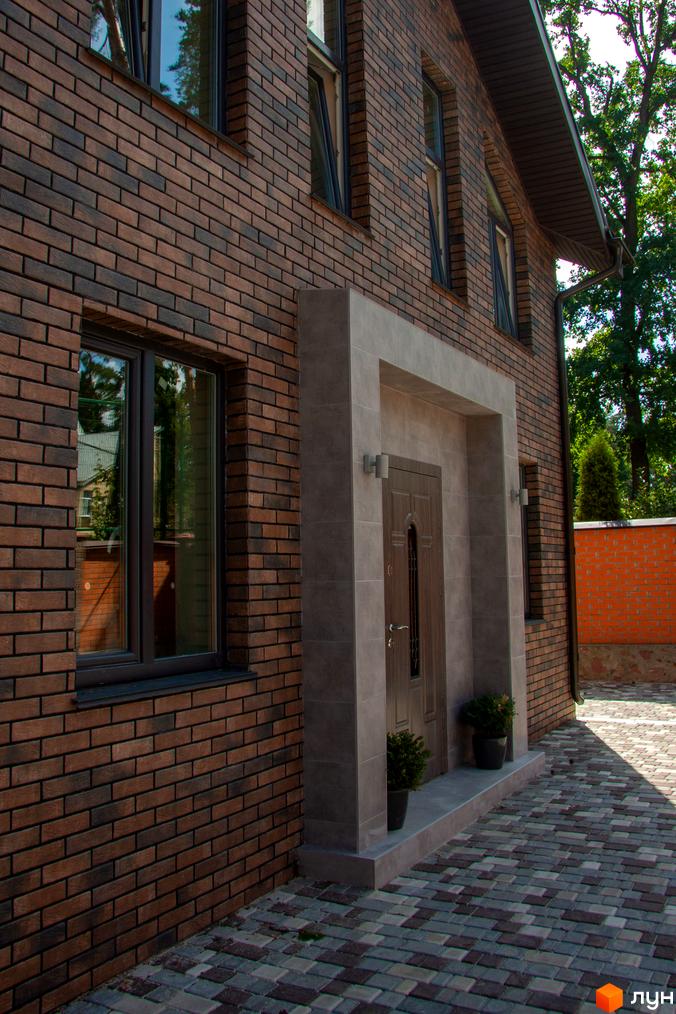 Таунхаус „На Кочубея“ з цегляним фасадом та облаштованою прибудинковою територією з бруківки.