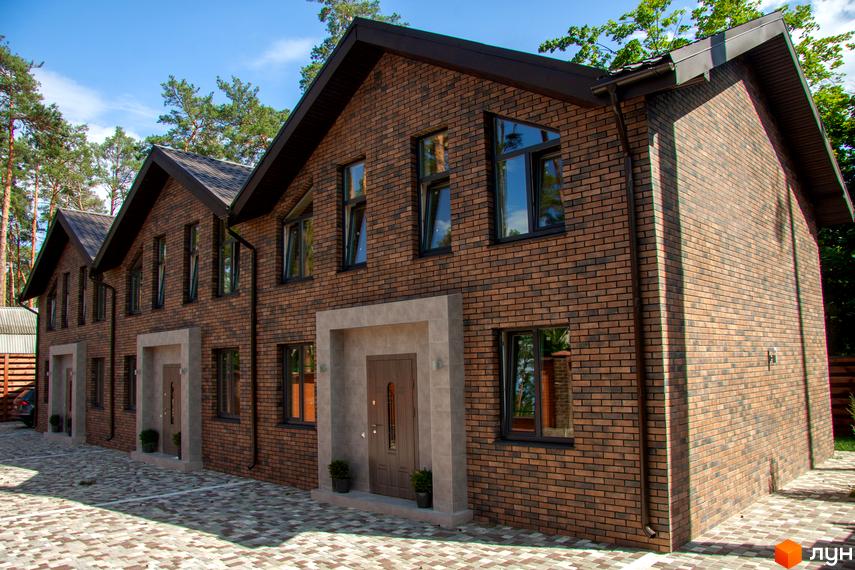 Таунхаус „На Кочубея“: фасади з коричневої цегли, великі вікна та вхідні групи. Прибудинкова територія вимощена плиткою, оточена деревами.