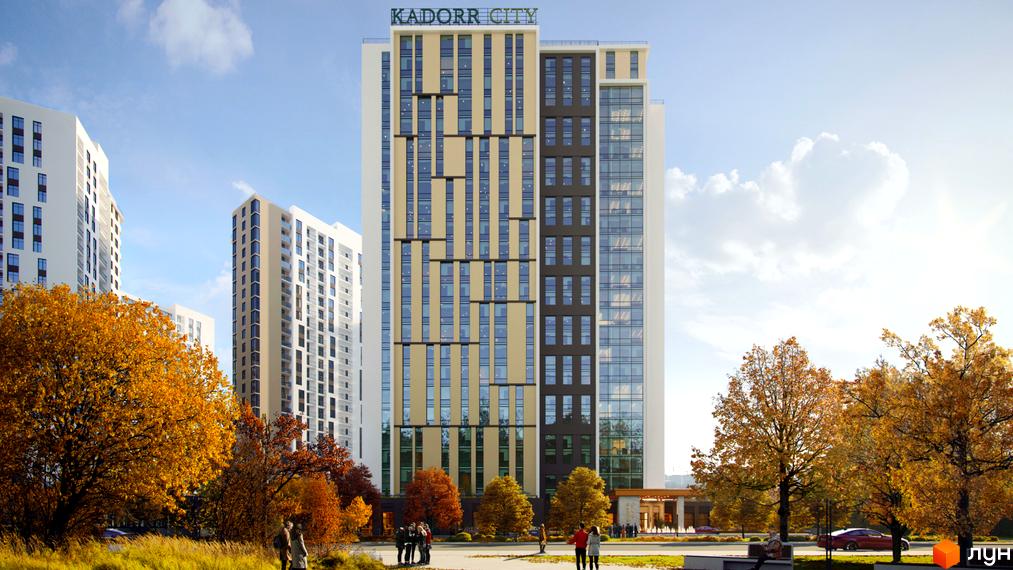Новобудова KADORR City з фасадом з вертикальних золотистих та темних панелей, великою кількістю вікон та скляних елементів. Навколо комплексу розташовані дерева з осіннім листям та зелена зона.