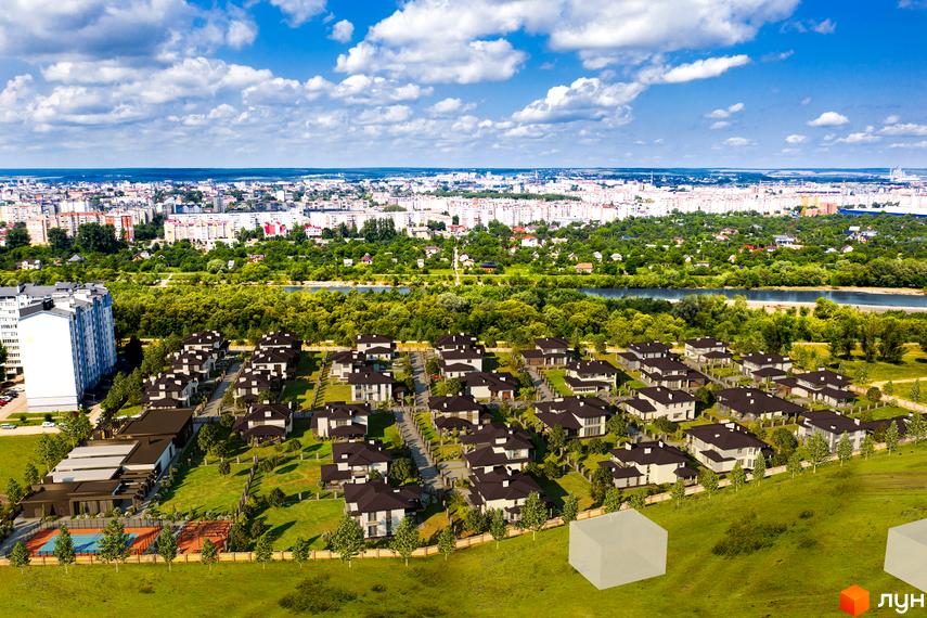 Котеджне містечко Franko River Club з сучасними будинками та доглянутою прибудинковою територією. На зображенні видно зелені зони та спортивні майданчики.