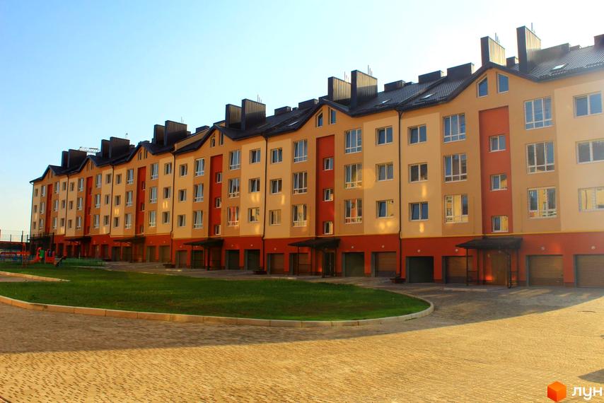 Зовнішній вигляд чотириповерхового будинку Житлового комплексу по вулиці Проектована-Тролейбусна, 3. На передньому плані прибудинкова територія.