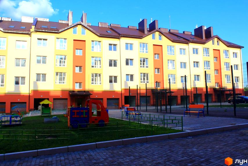 Зображення фасаду та дитячого майданчика Житлового комплексу на вулиці Проектована-Тролейбусна, 3. Вигляд на будівлю та прибудинкову територію.