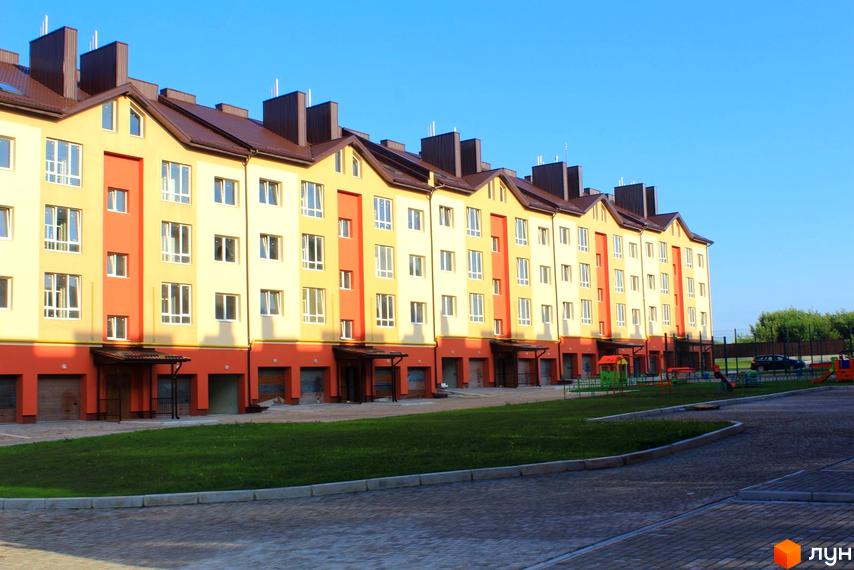 Зображення фасаду будинку по вулиці Проектована-Тролейбусна, 3. На території є газон та дитячий майданчик.