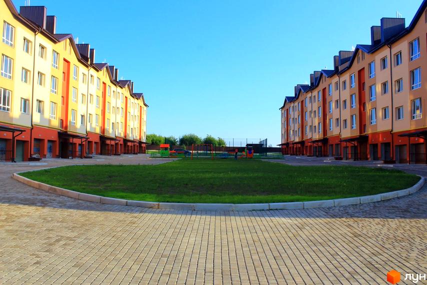 Зовнішній вигляд будинків на вулиці Проектована-Тролейбусна, 3. На території житлового району розташований дитячий майданчик.