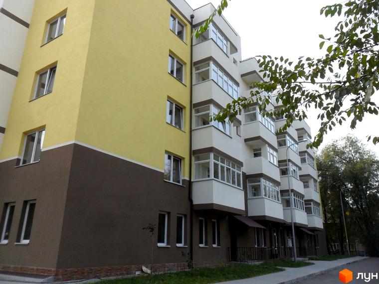 Зображення житлового будинку на бульварі Чоколівському, 27б. Багатоповерхова будівля з балконами та вікнами, поряд зелені дерева та тротуар.