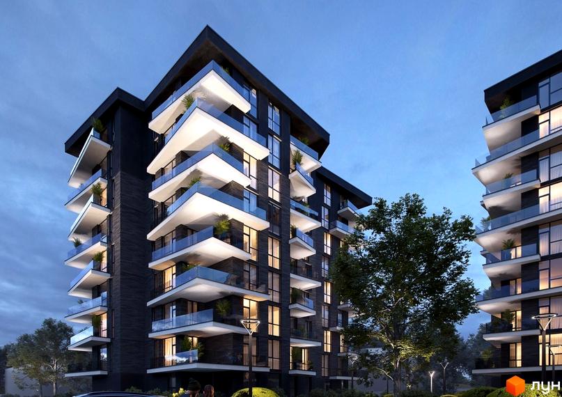 Житловий комплекс Artynov Hall: багатоквартирний будинок з темною цегляною кладкою та світлими балконами зі скляними перилами, освітлений ввечері серед дерев.