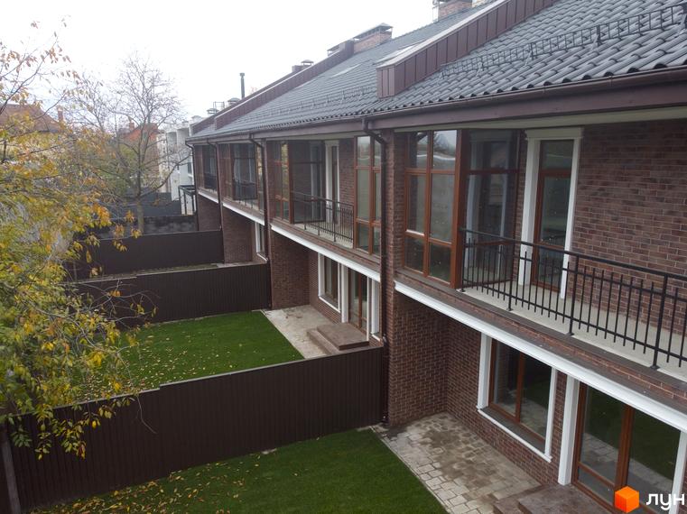 Вид на таунхауси житлового комплексу „Протасів Residence“ з цегляними фасадами, балконами та доглянутою прибудинковою територією з газоном.