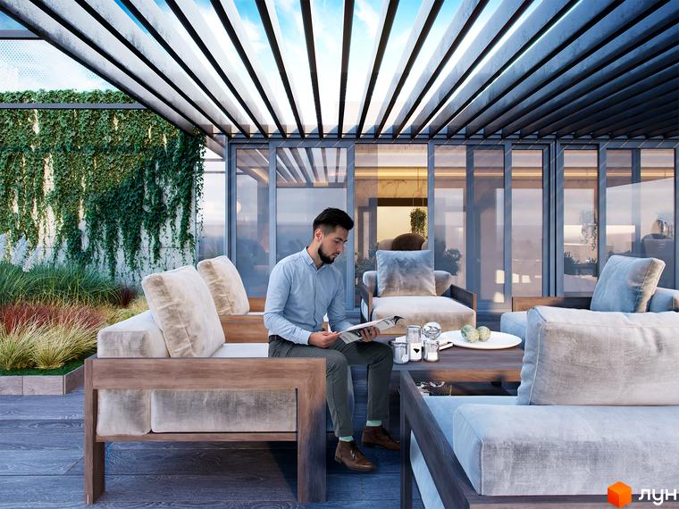 Зображення тераси Житлового комплексу Krauss Gallery з м'якими меблями та чоловіком, що читає газету. На задньому плані зелені насадження та скляні перегородки.