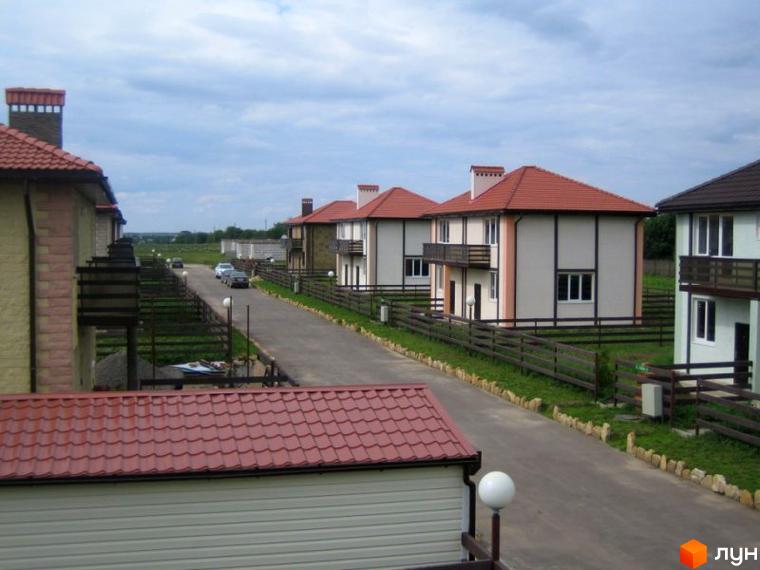Зображення сторінки житлового комплексу КМ Fresh Town. На фото видно двоповерхові будинки з червоними дахами та огородженою територією.