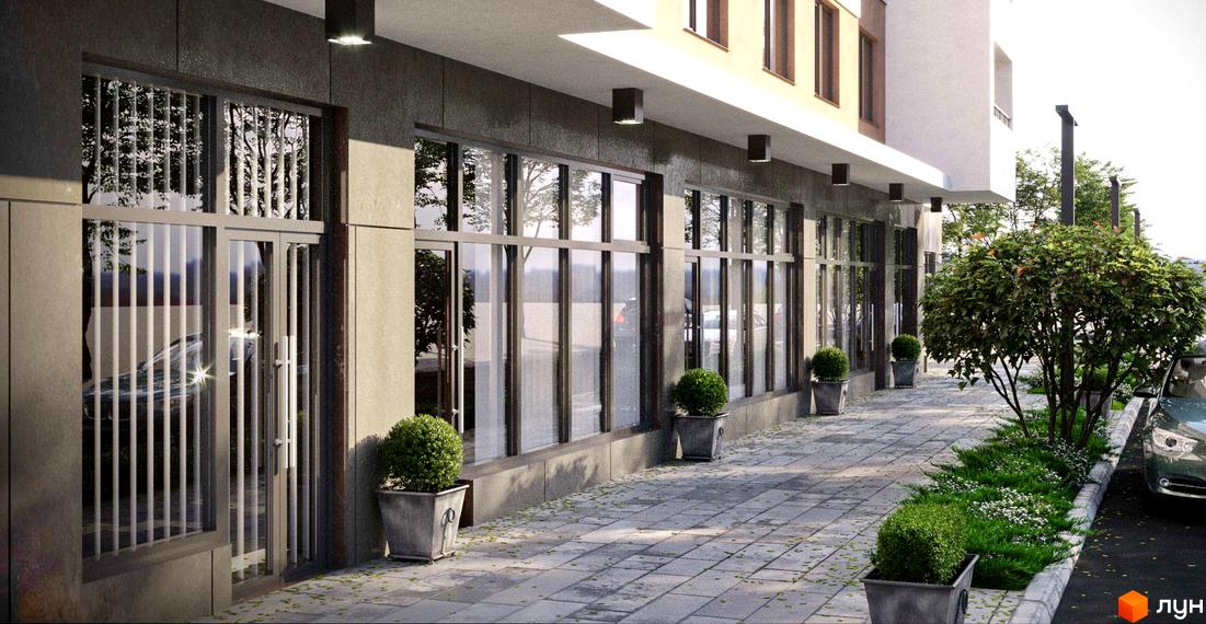 Фасад Житлового комплексу Удобний з великими вікнами на першому поверсі. Перед будинком викладений плиткою тротуар та зелена зона з деревами.