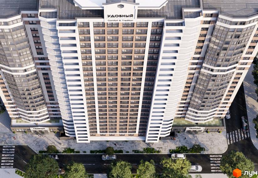 Житловий комплекс Удобний з високими світлими фасадами та численними вікнами. Вид зверху на будівлю та прилеглу територію з дорогою, пішохідними переходами та деревами.