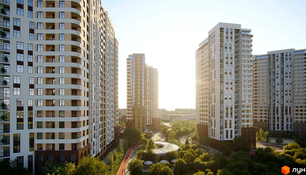 Новобудова KADORR City з білими та бежевими фасадами, балконами та панорамними вікнами, оточена зеленим парком з доріжками для прогулянок.