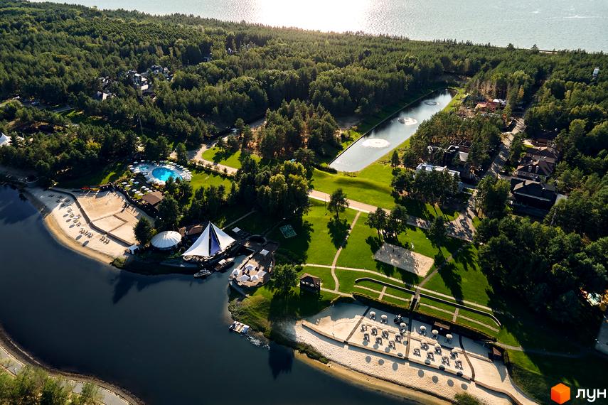 Вид на житловий комплекс КМ Riviera Village з висоти. Прибудинкова територія з зеленими насадженнями, пляжем та басейном.