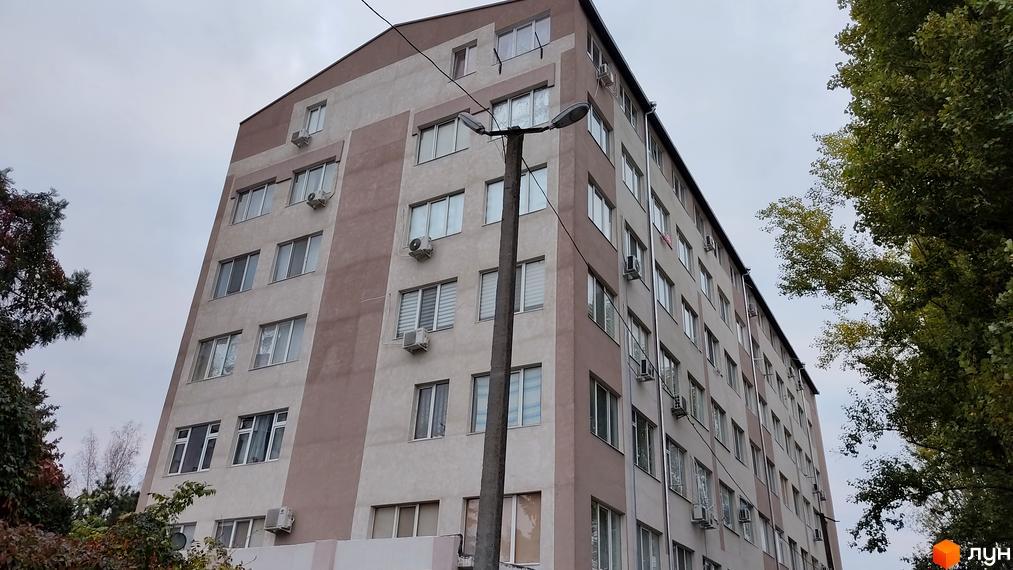 Багатоповерховий житловий будинок Житловий комплекс Будинок на Боровського з фасадом світло-коричневого та бежевого кольорів. Поруч видно дерева та вуличний ліхтар.
