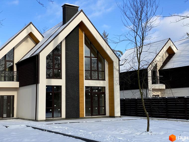 Зображення будинку в Котеджному містечку BARN HOUSE. Двоповерховий будинок з великими вікнами та снігом на подвір'ї.