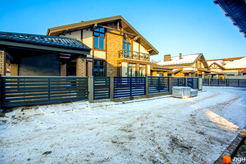 Котеджне містечко LakeWood. Будинки з цегляним фасадом та темним дахом, огороджені металевим парканом. Прибудинкова територія вкрита снігом.