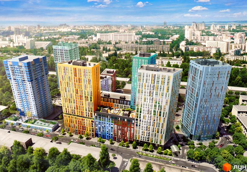 Зовнішній вигляд ЖК Малахіт: багатоповерхові будинки різної висоти та кольору, з сучасними фасадами. Навколо зелена зона та дороги з автомобілями.
