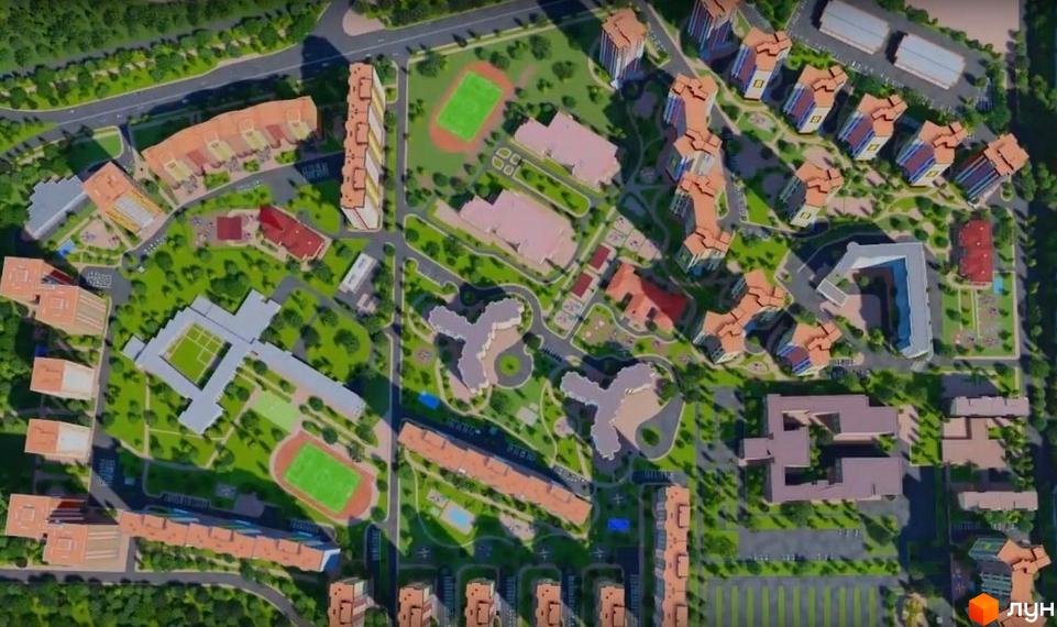 Вид згори на житловий комплекс Еврика з багатоповерховими будинками та зеленою прибудинковою територією. На території комплексу розташовані спортивні майданчики та зони відпочинку.