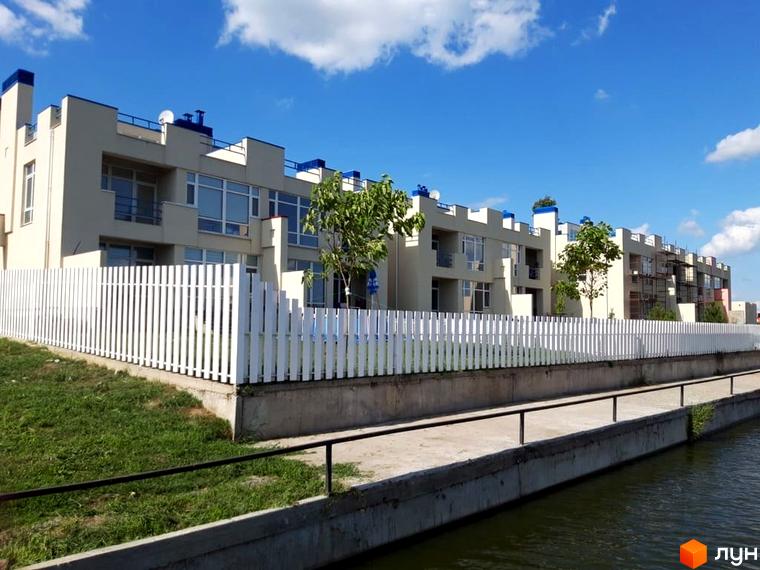 Таунхауси Lake City - це сучасні будинки з білими парканами та зеленою зоною біля води. Зовнішній вигляд новобудови відповідає європейським стандартам.